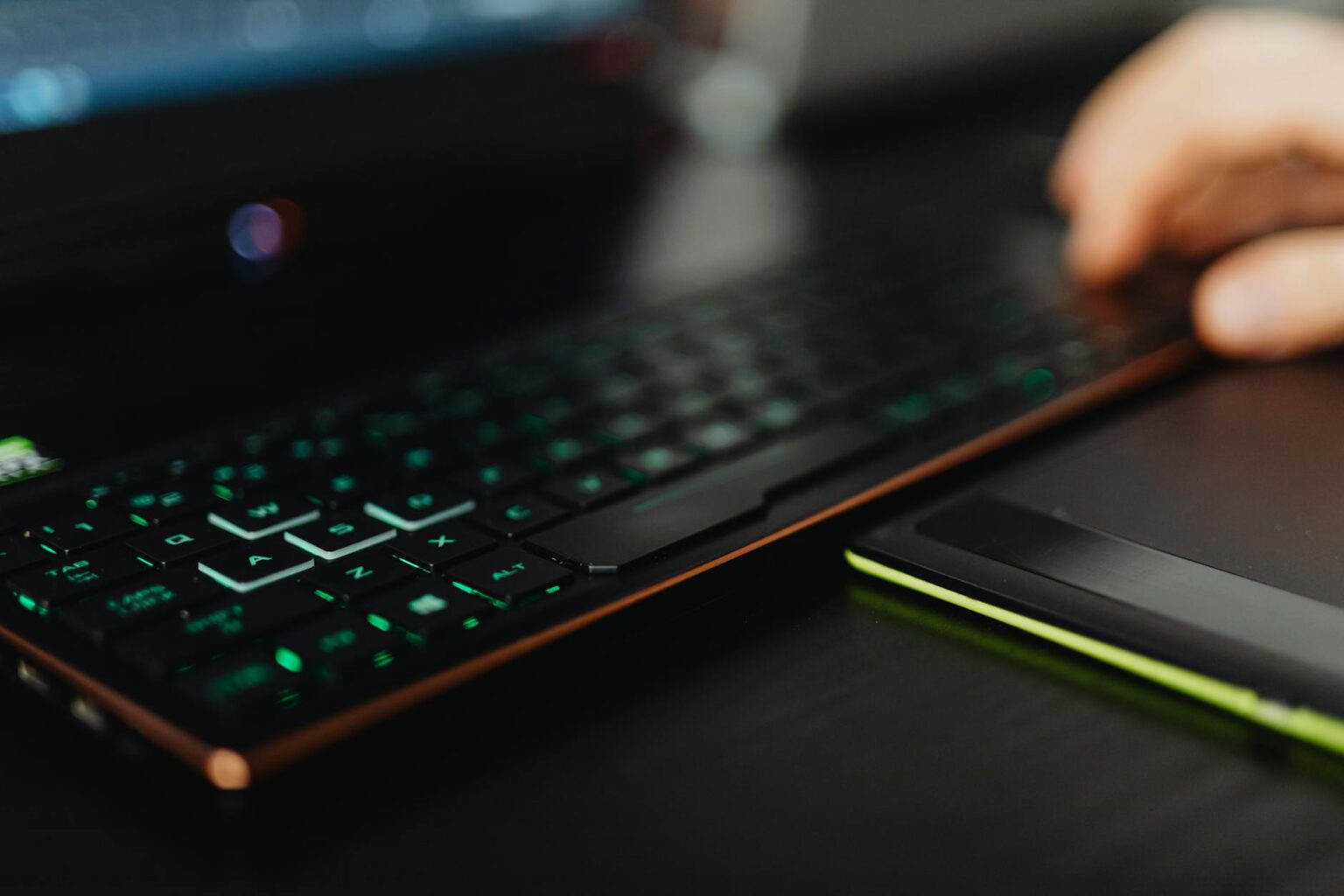 Modern gaming laptop setup with RGB keyboard illumination on desk