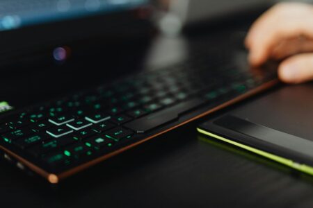 Modern gaming laptop setup with RGB keyboard illumination on desk