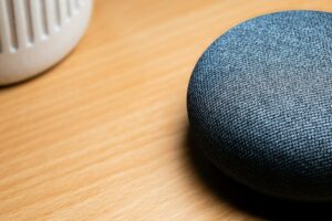 Modern smart speaker device on wooden table representing voice assistant technology