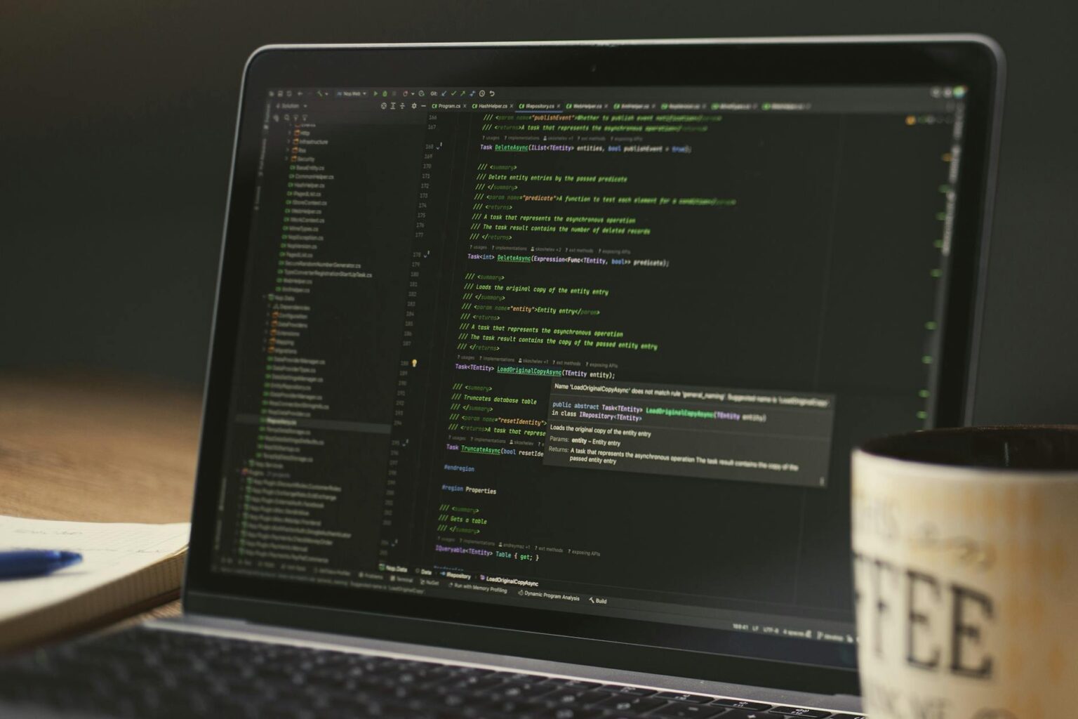 Developer working on code with laptop showing programming interface and code editor
