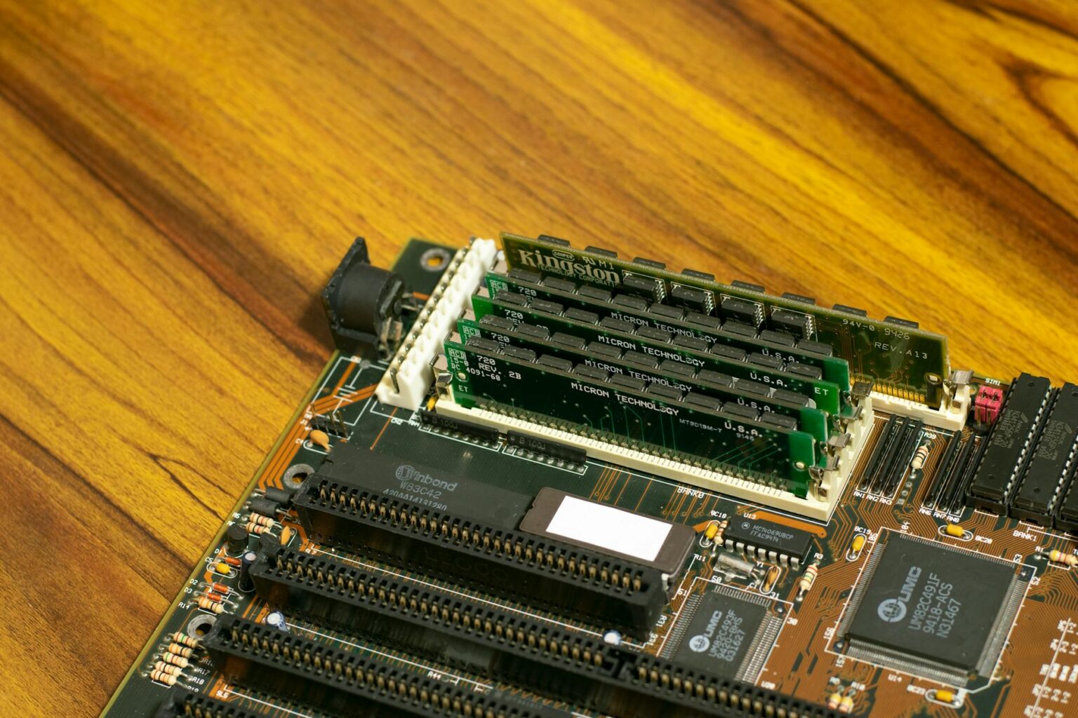 Computer motherboard and various PC components laid out on a workspace showing the building blocks of a custom gaming PC