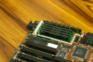 Computer motherboard and various PC components laid out on a workspace showing the building blocks of a custom gaming PC