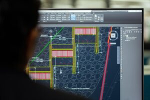Designer working on interface mockups displayed on computer screen