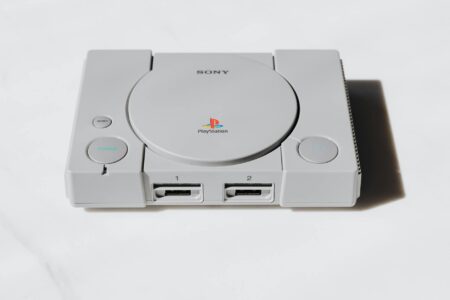 Modern handheld gaming device on desk with controllers and accessories