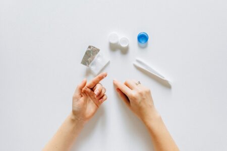 Close-up view of a contact lens being held on fingertip showing transparent material and curved shape