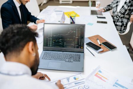 Professional business laptop on office desk with documents and coffee