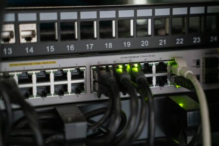 Modern wireless router with ethernet cables and LED status lights on a desk