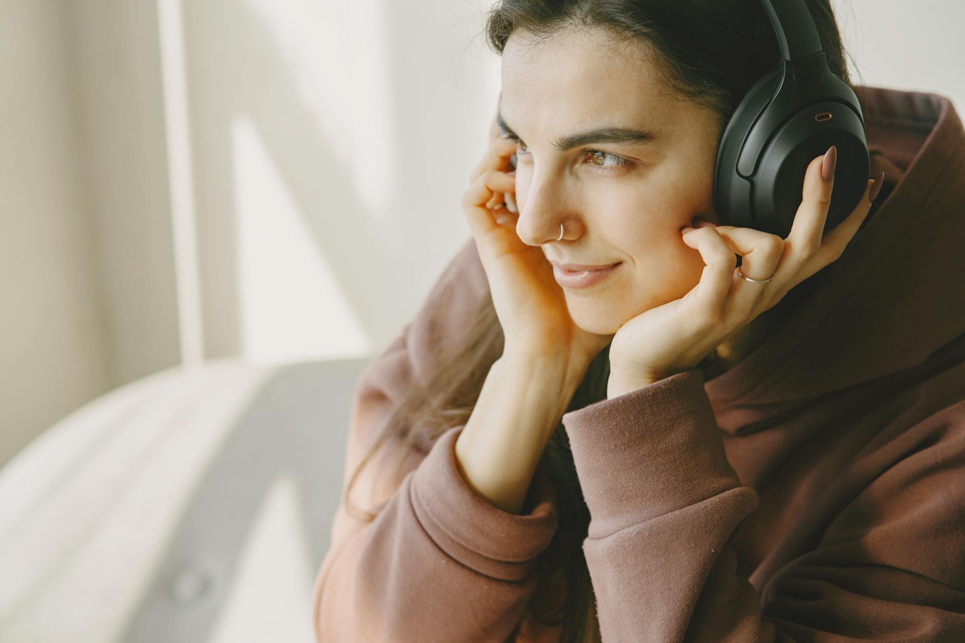 Person wearing wireless earbuds while using smartphone