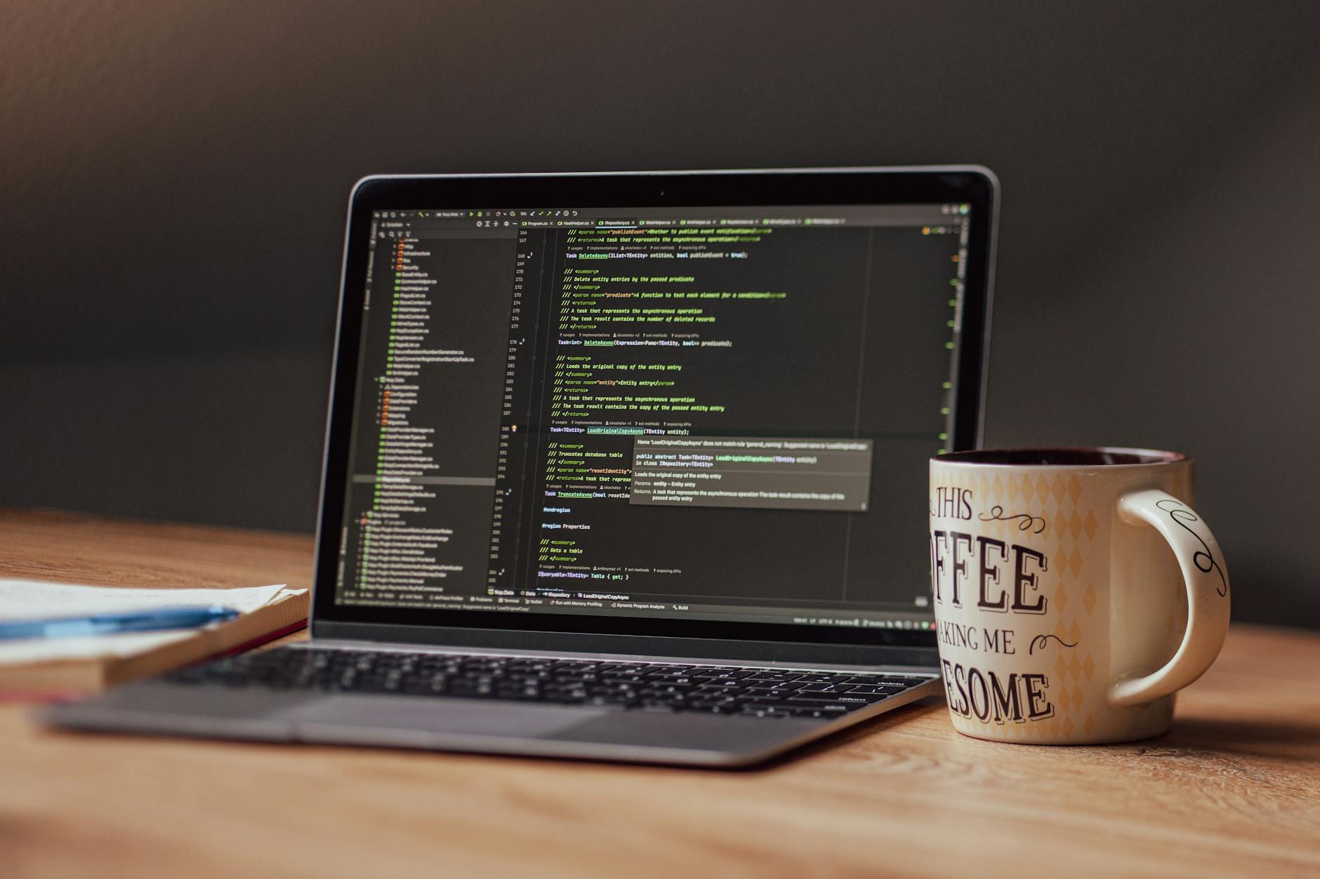 Professional programming workspace with laptop, external monitors, and development tools setup