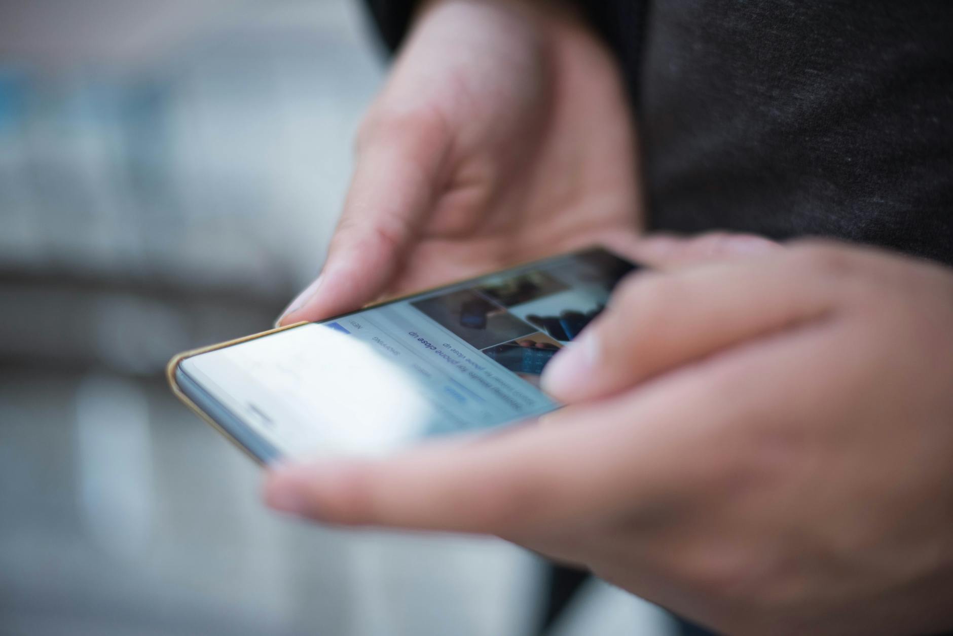 Hands holding smartphone showing mobile app interface for task management