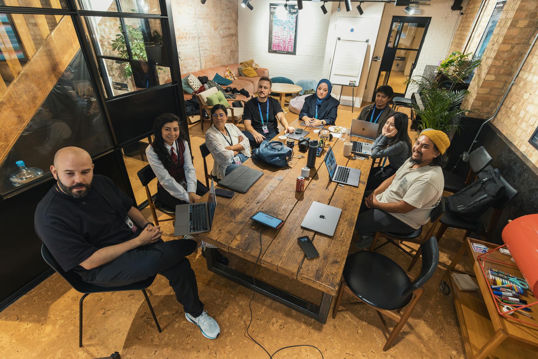 Professional team meeting discussing technology solutions around conference table