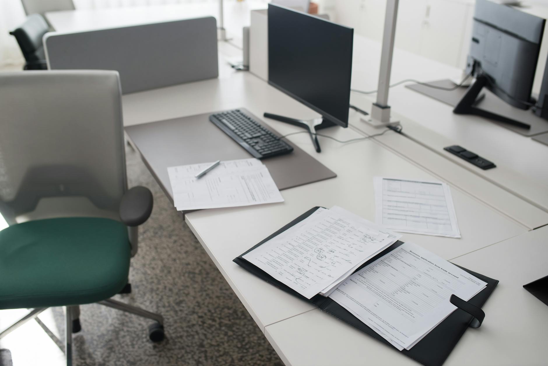 Clean modern workspace setup with large monitor and photography equipment