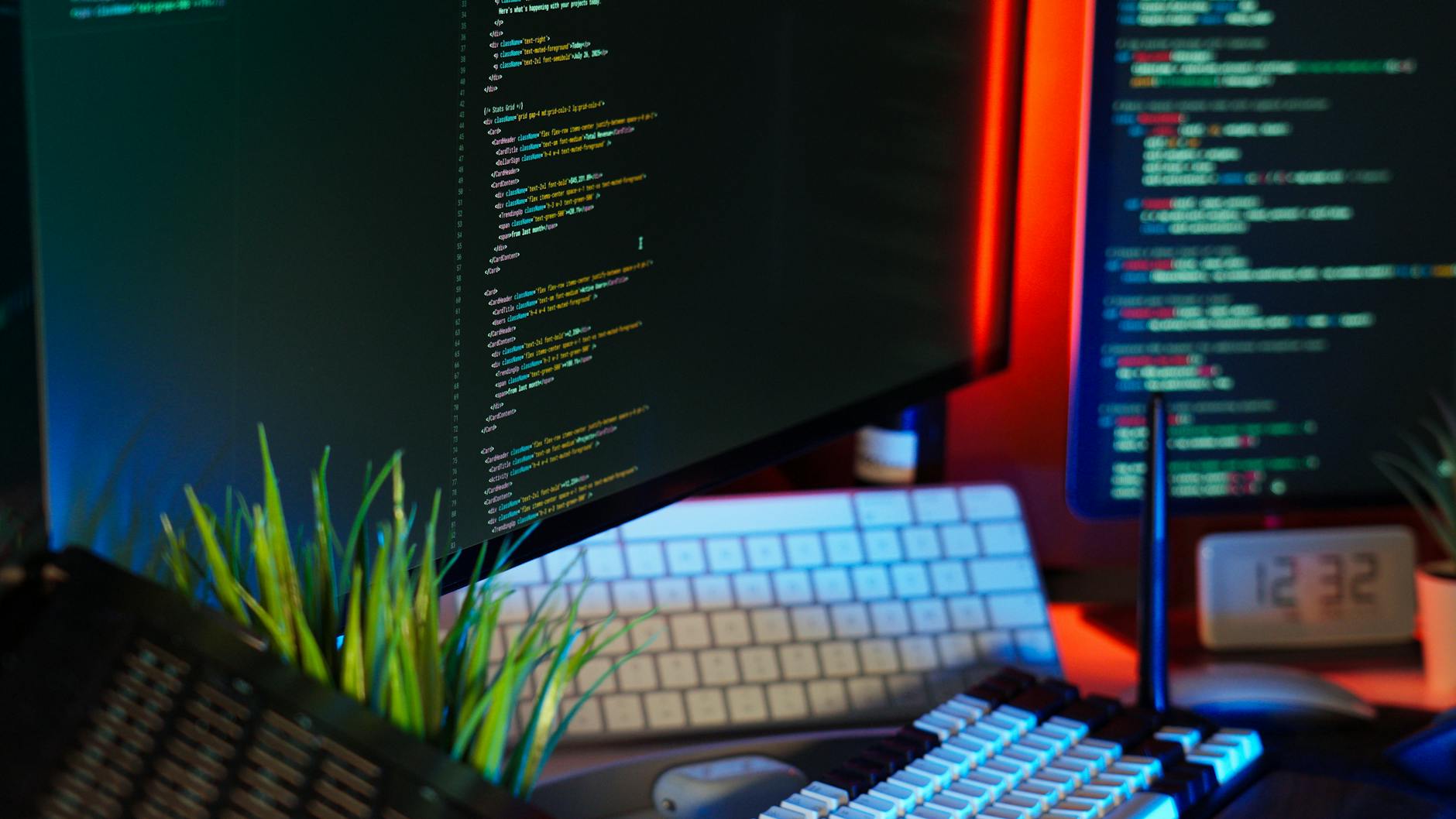 Clean modern workspace with laptop, external monitor, and coding environment setup