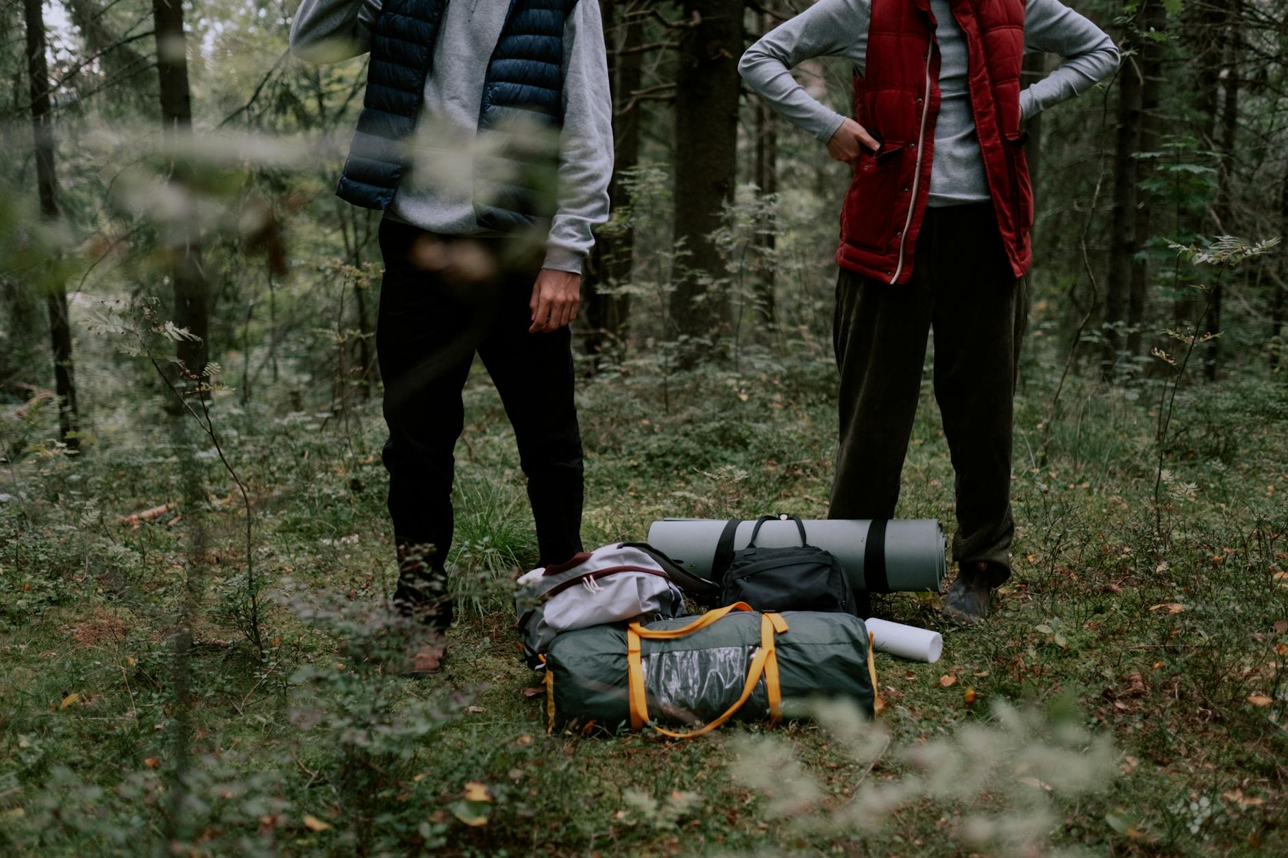 Outdoor camping and hiking gear laid out including navigation equipment and adventure accessories
