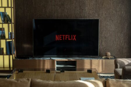 Sonos Arc Ultra vs Bose Smart Soundbar 900: Best Home Theater Bar A modern living room home theater setup with a large TV and soundbar on a media console