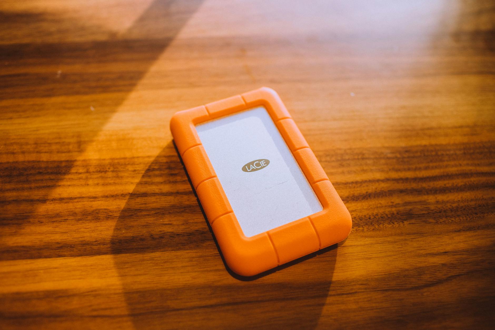Compact USB SSD drive connected to a laptop in a mobile work setup