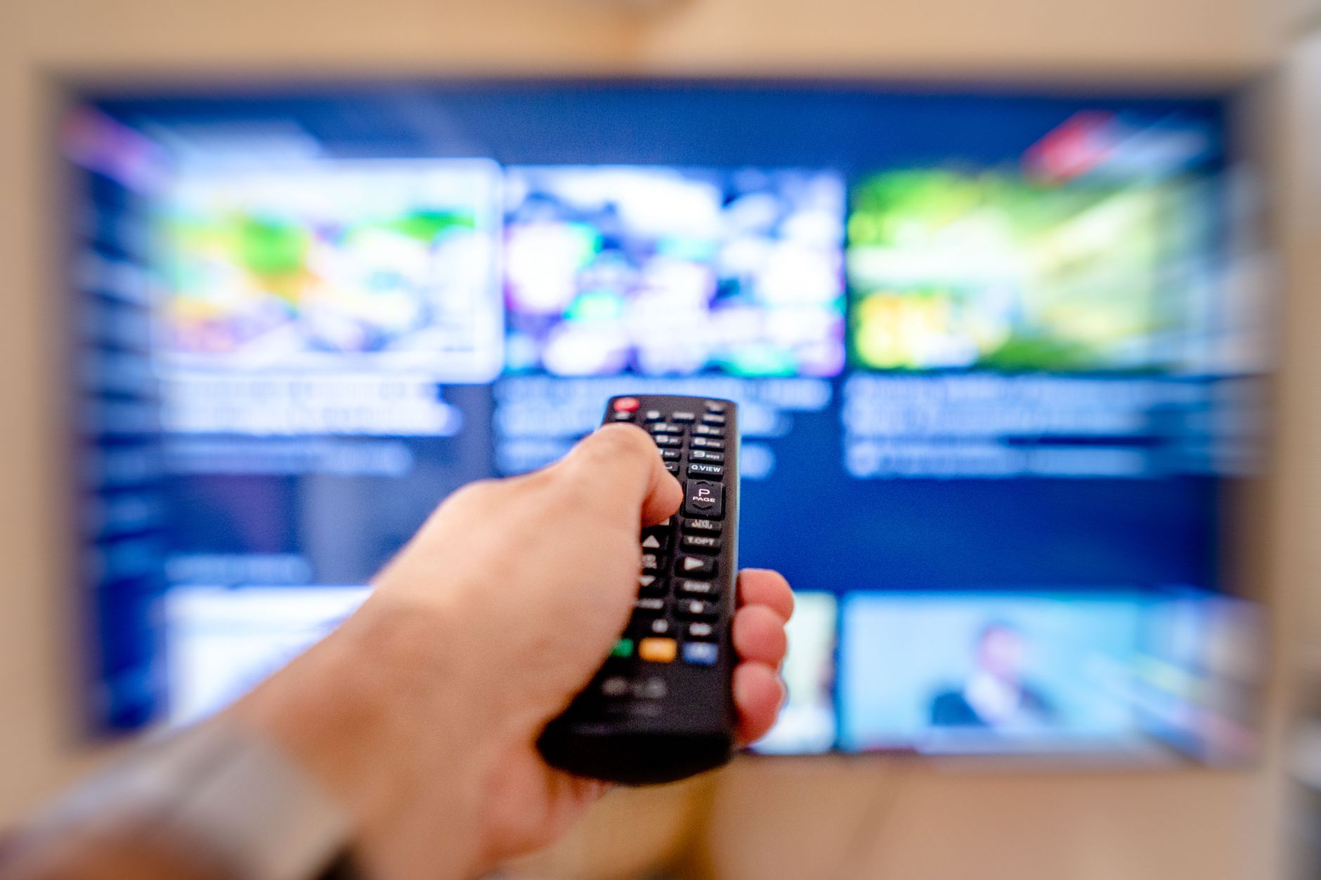 Person browsing a media streaming interface on a living room television