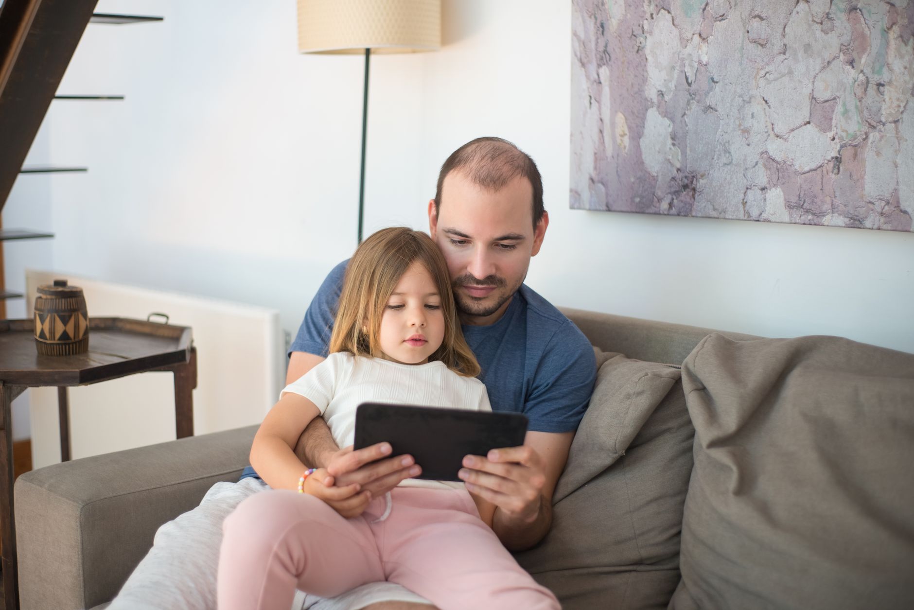 Person reading manga on a tablet device connected to a digital library