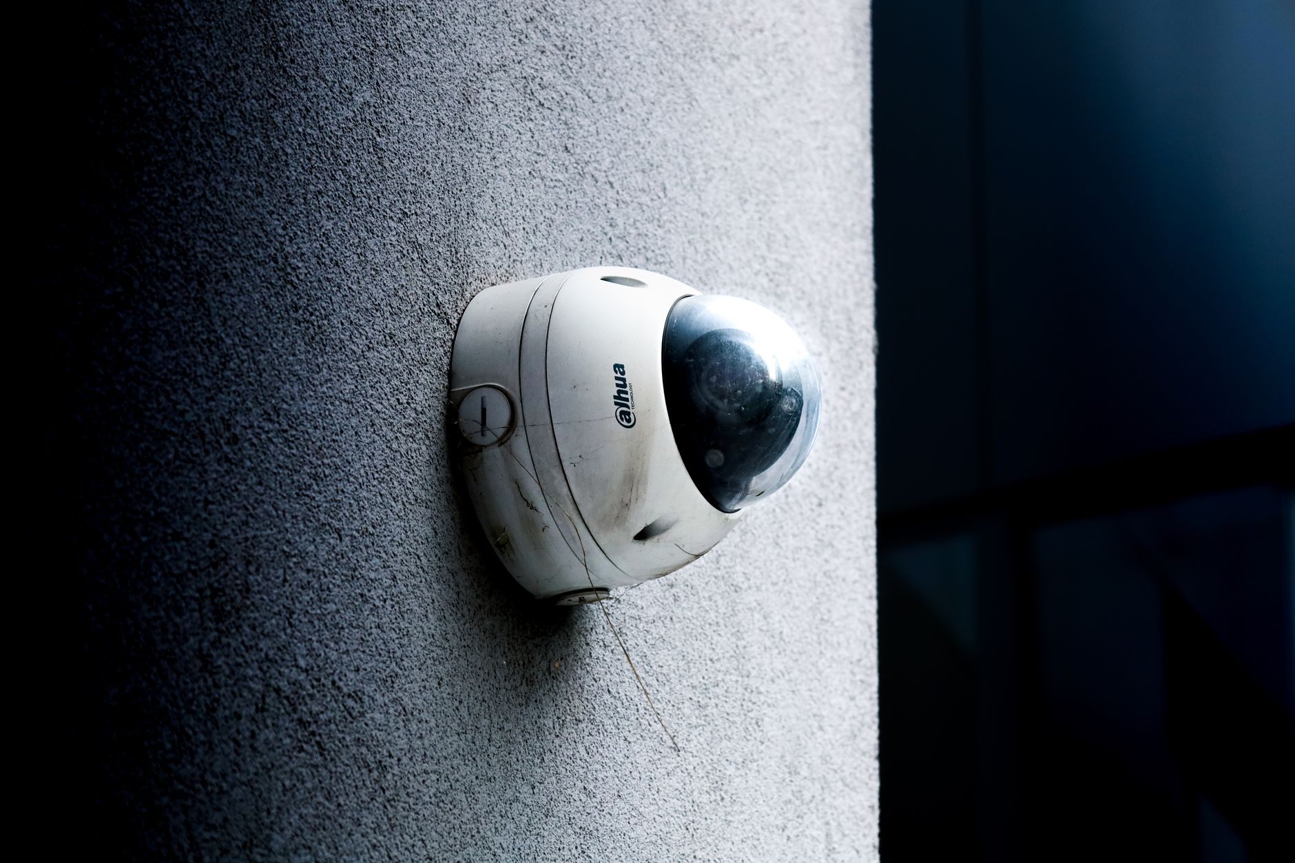 A home security camera mounted on an exterior wall near a front door