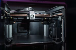 A compact desktop 3D printer in operation, printing a small object