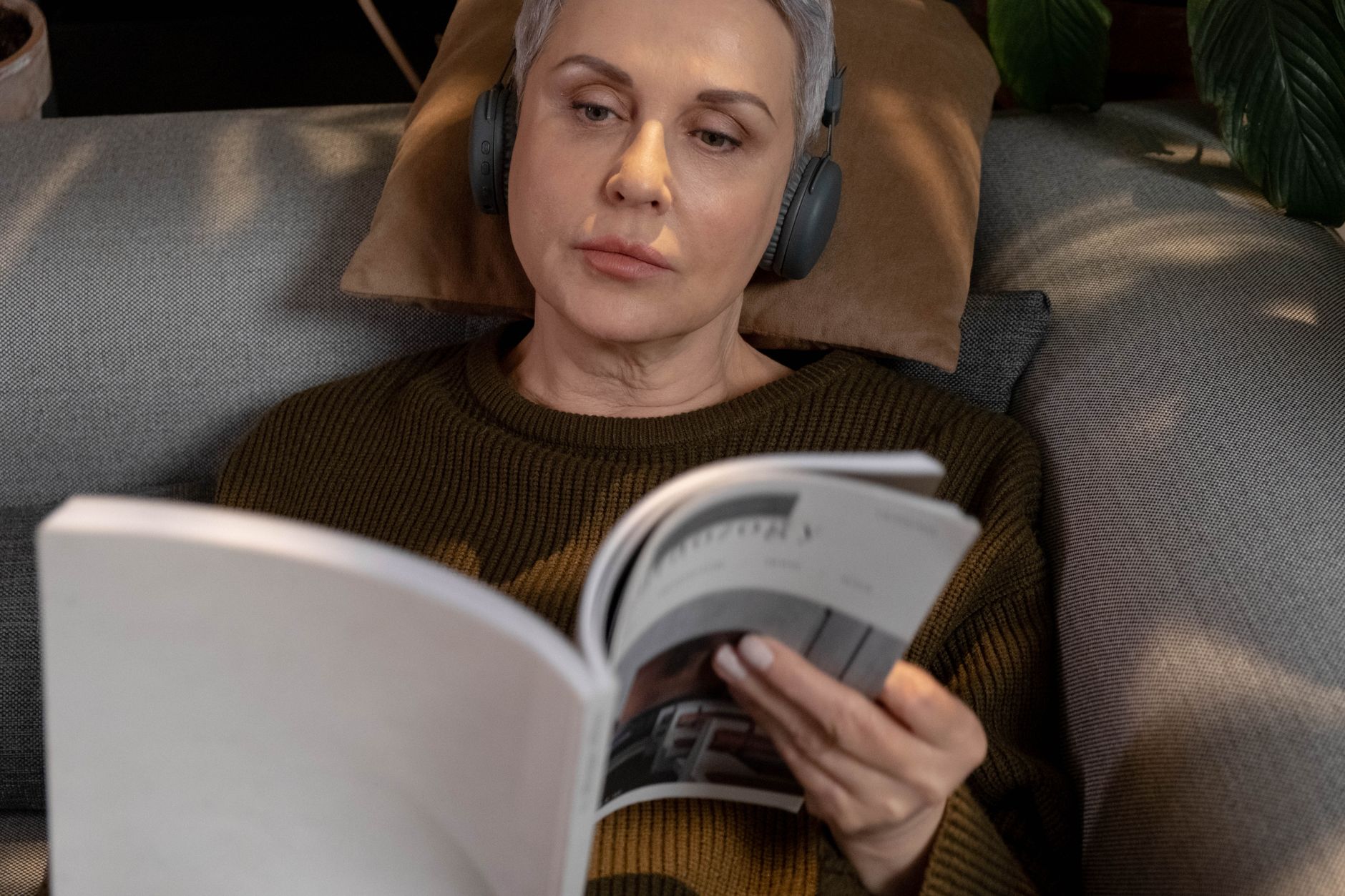 Person listening to an audiobook through headphones on a mobile device