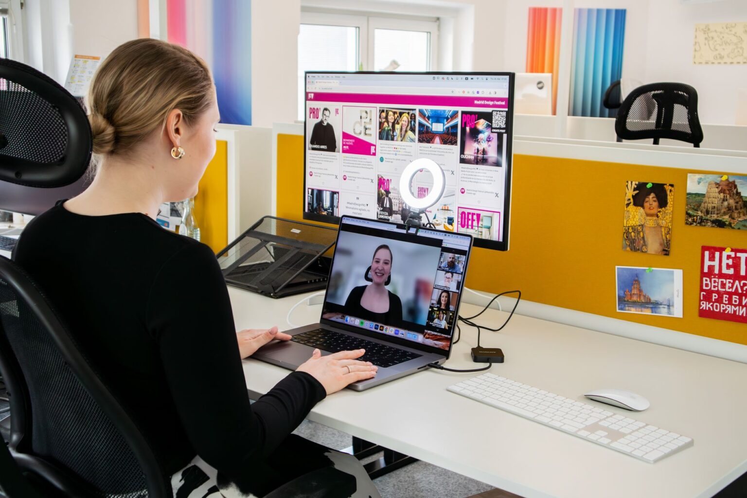 Person participating in a video conference call at a desk with a laptop