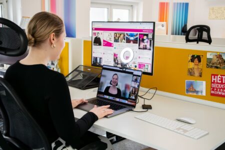 Person participating in a video conference call at a desk with a laptop