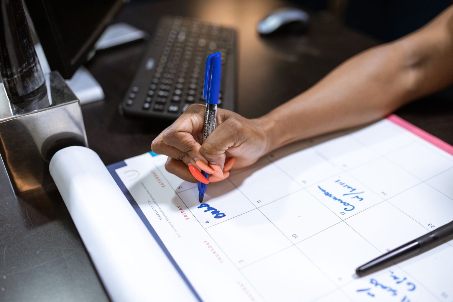 A weekly meal planner notebook open on a desk with handwritten recipe notes